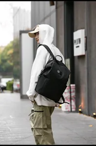 Close-up of the side zipper pocket on a black water-resistant nylon backpack for travel