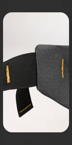 Detailopname van de grijze stoffen riem met gele versterkte stiksels op de borsttas