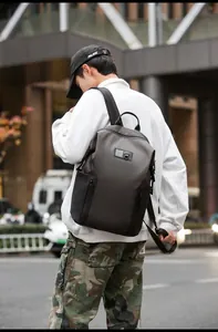 Outdoor city street view of a man wearing a durable charcoal grey travel backpack