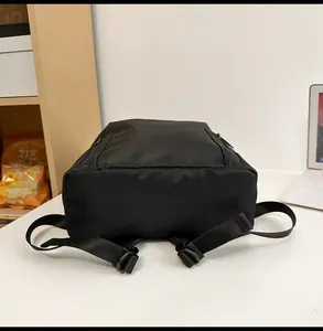 Detail view of the durable black nylon backpack with zip pockets and sturdy straps