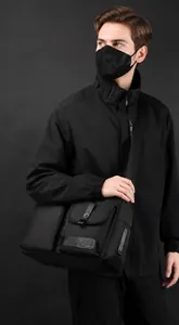 Close-up of waterproof nylon shoulder bag with buckle pockets and tactical patches