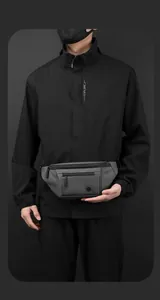 Detail view of a waterproof dark gray men's waist bag featuring multiple zipper pockets