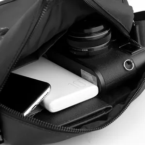 Waterproof nylon crossbody bag showing main storage for camera, phone and power bank