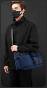 Detail view of navy blue crossbody bag showing dual storage pockets and durable nylon fabric