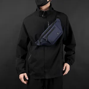 Waterproof navy blue sports chest bag for men worn by a model in outdoor jacket