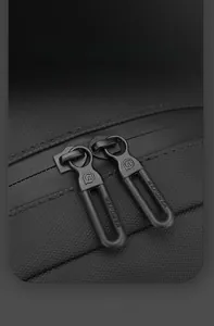 Detail of dual matte alloy zippers on black scratch-resistant nylon crossbody bag
