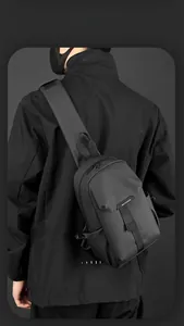 Rear view of minimalist black waterproof nylon chest bag with adjustable padded strap
