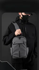 Detailed view of the water-resistant gray crossbody bag with multi-pocket storage and logo