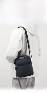 Macro shot of durable blue nylon fabric and front zipper pocket on the men's crossbody bag