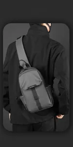 Rear view of minimalist dark grey waterproof nylon crossbody chest bag on male model