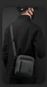 Detail view of water-resistant dark grey shoulder bag with adjustable strap and zip pockets
