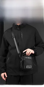Detail of waterproof nylon crossbody bag featuring adjustable strap and multi-pocket design