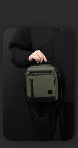 Macro detail of waterproof olive and black shoulder bag showing textured fabric and zippers
