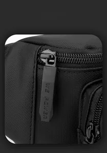 Close-up of matte metal zipper with brand logo on black textured honeycomb nylon fabric