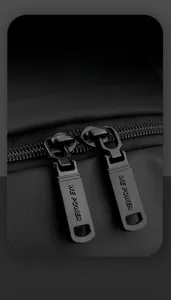 Detail of smooth metal double zippers with logo on black water-resistant chest bag