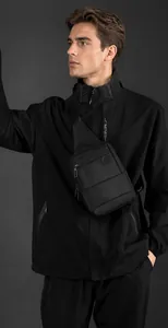 Close-up of black crossbody chest bag with adjustable strap on a male model