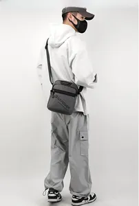 Detailed view of grey nylon messenger bag with front zipper pocket and durable texture