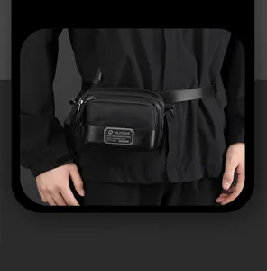 Detail of a black nylon crossbody waist bag featuring a dual zipper and brand logo