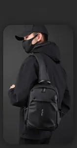 Close-up of black waterproof chest bag featuring a front pocket and elastic side cord