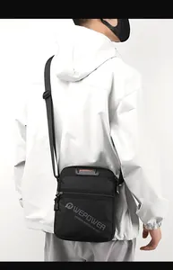 Close-up of black crossbody bag showing waterproof nylon texture and gray brand logo