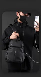 Detail of waterproof casual chest bag for men showing built-in USB charging port and logo