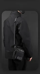 Detail of waterproof nylon shoulder bag featuring metal zippers and adjustable strap