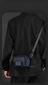Macro detail of navy blue waterproof nylon crossbody bag with WE POWER logo label