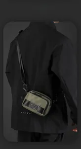 Olive green waterproof nylon crossbody bag shown worn by a model in a urban style