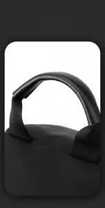 Detail of reinforced black PU leather handle and waterproof nylon texture on men chest bag