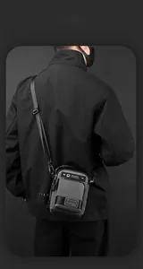 Detail of grey waterproof crossbody bag with multiple storage pockets and adjustable strap