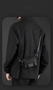 Detail of a black tactical crossbody bag showing durable nylon texture and adjustable strap