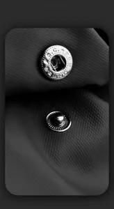Macro shot of high-quality metal snap buttons on durable textured crossbody bag