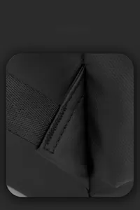 Gros plan sur les coutures renforcées des bretelles et le tissu imperméable du sac