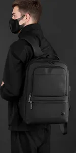 Detalle de la textura impermeable y las elegantes cremalleras metálicas en la mochila negra