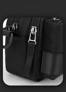 Detail of smart storage space featuring metallic zippers on black men's shoulder bag