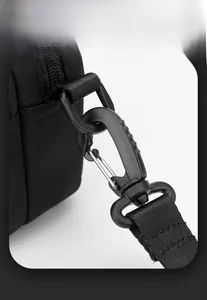 Detail of durable nylon strap with D-ring and metal spring hook on a black bag
