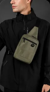 Detail view of olive green crossbody bag with durable nylon material and multiple zippers