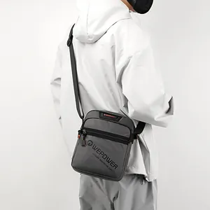 Deep grey minimalist men's crossbody bag with adjustable strap on white background