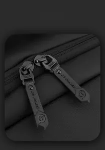Close-up of SBS metal zipper with textured non-slip puller on black laptop backpack