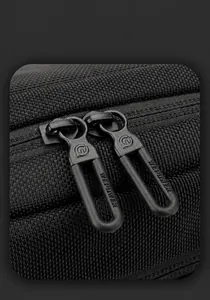 Close-up of durable nylon texture and branded dual zippers on the black sling bag