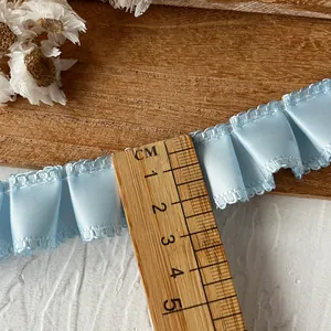Light blue ruffled ribbon for DIY crafts measuring approximately 2.5cm width with wood ruler