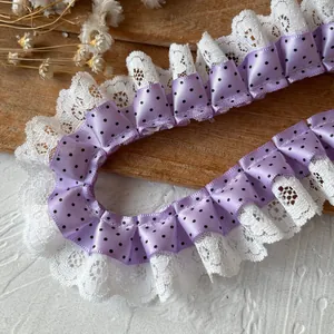 Detail of purple polka dot ribbon and white pleated lace trim for DIY sewing crafts
