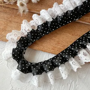 Close-up of double-layer pleated black polka dot ribbon with white lace for DIY sewing