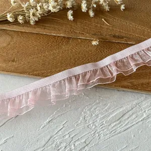 Detail of light pink elastic ruffled lace trim for DIY sewing and bridal clothing decor