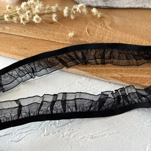 Macro detail of black pleated ruffle lace trim with mesh texture for DIY sewing and crafts