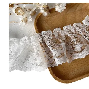 Bordo in pizzo bianco plissettato con motivi floreali per abbigliamento Lolita su vassoio