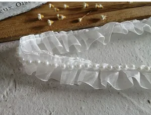 Detail of white organza ruffled lace trim with pearls for clothing and DIY crafts