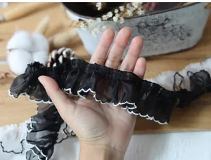 Detail of 4cm black pleated lace with white scalloped edges for DIY sewing projects