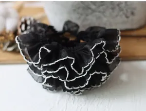 Macro shot of 4cm wide black ruffled lace trim with white edge for DIY clothing sewing