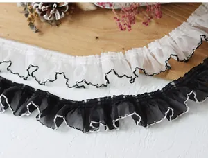 Detailed view of 4cm pleated lace trim in black and white with contrast wavy edges